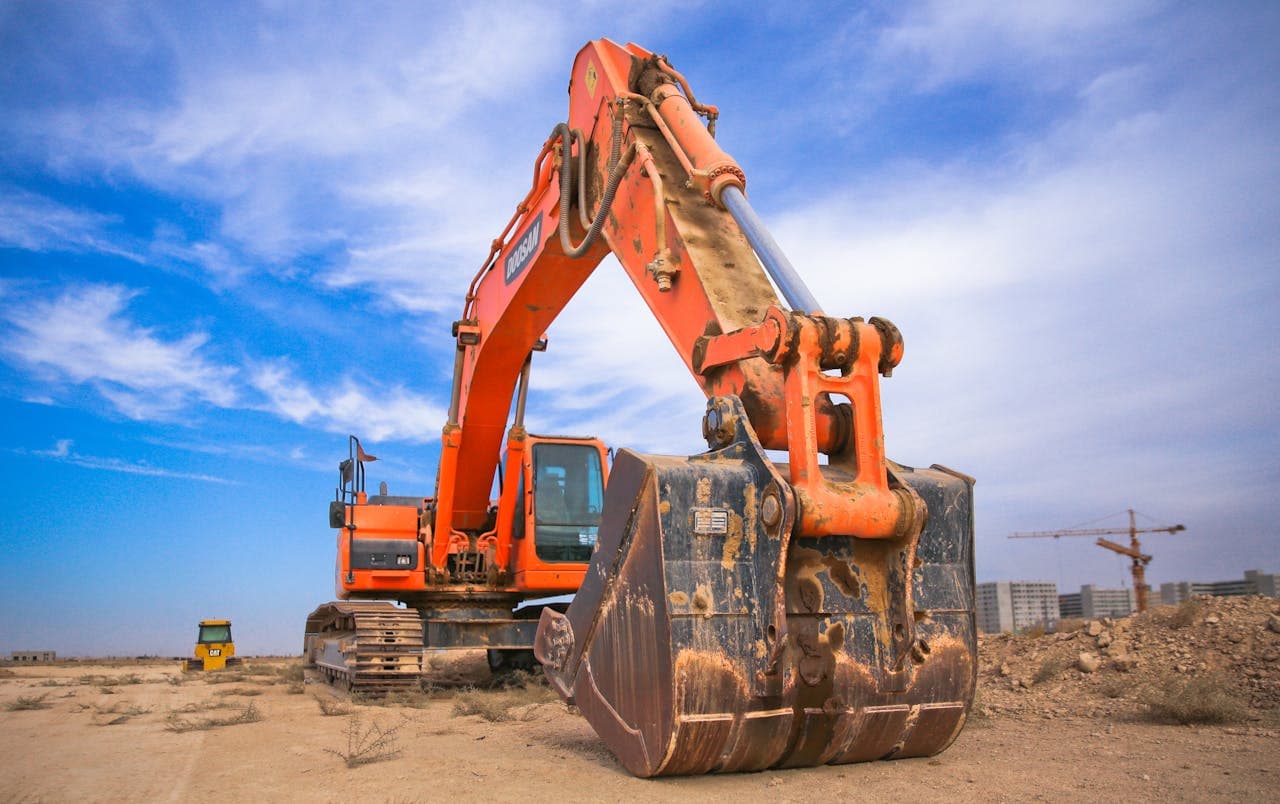 Heavy construction equipment lined up at an auction yard, representing how to buy equipment at auction
