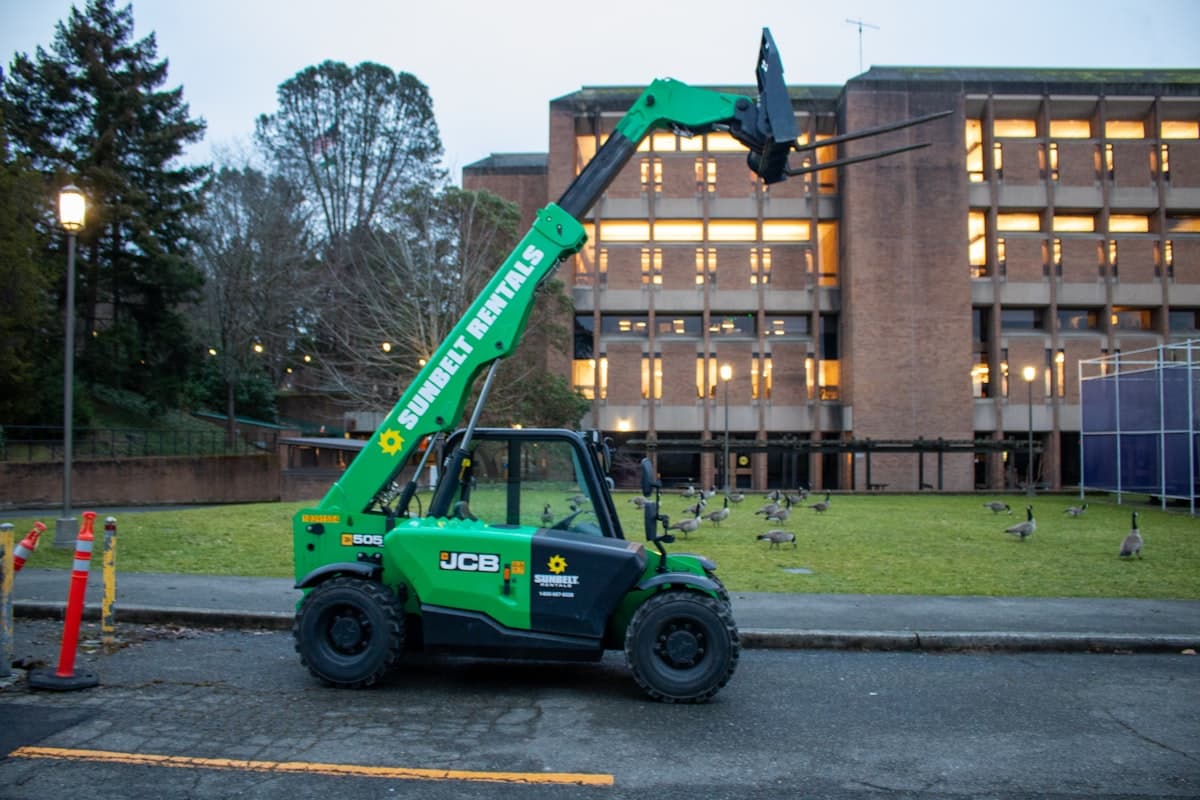 Used telehandler with extended boom on a construction site, representing 2026 telehandler pricing data
