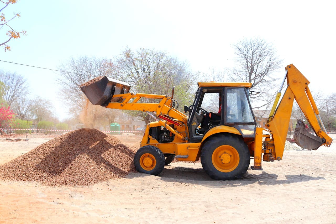 Yellow wheel loader working at a construction site, representing used wheel loader market pricing