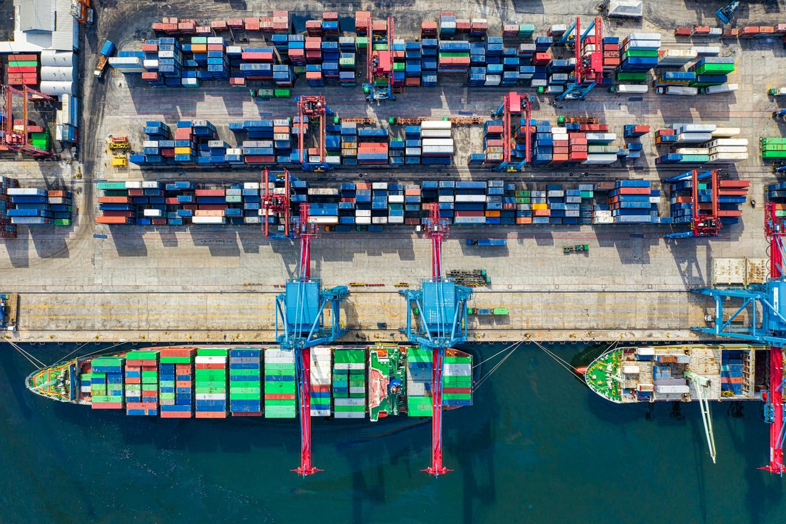 Imported heavy equipment staged at a US port of entry in 2026, illustrating how Section 301, USMCA, and Section 232 tariffs are reshaping used construction and farm equipment prices