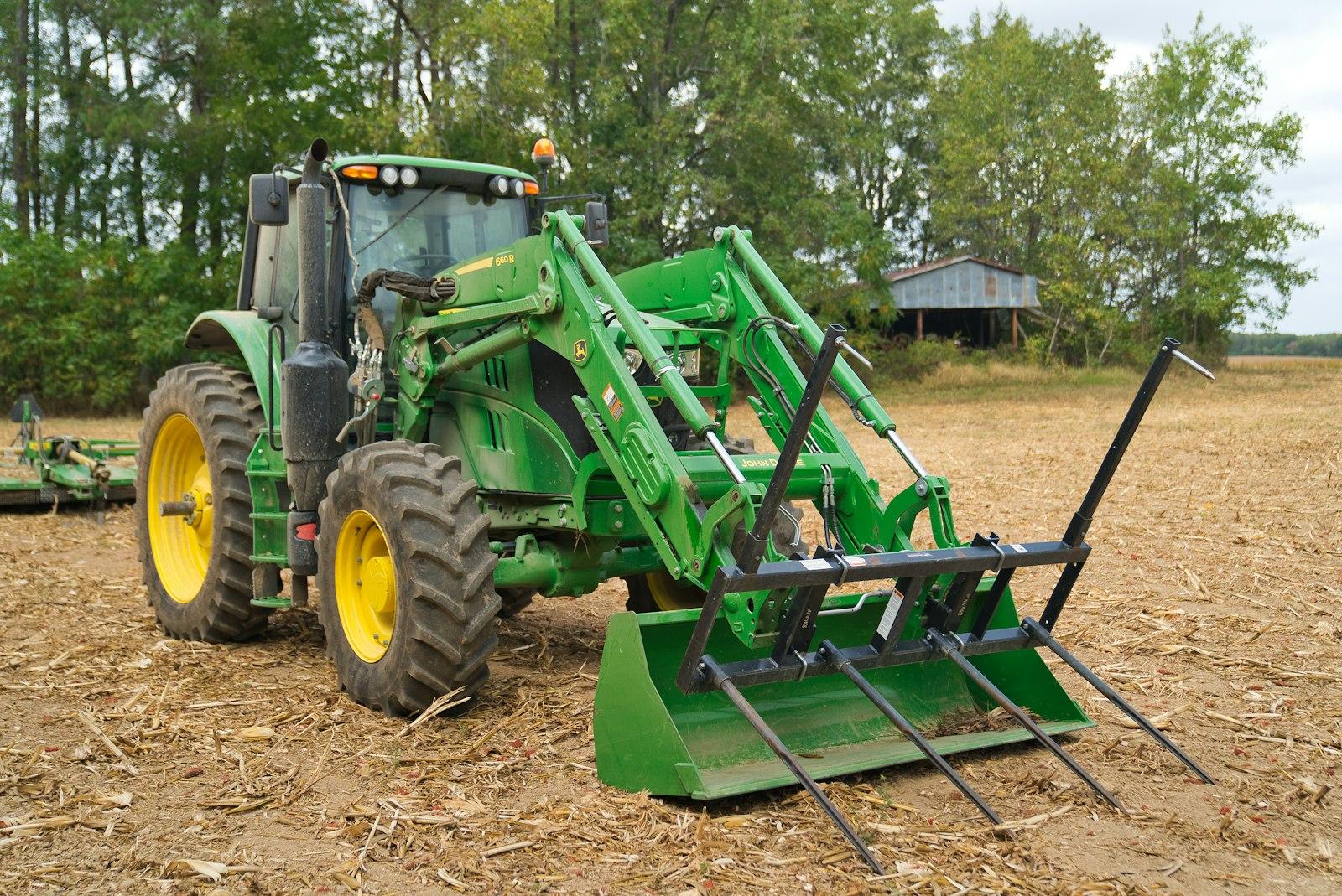 John Deere compact tractor in a freshly cut farm field — comparing the 1, 2, 3, and 4 Series lineup for 2026 buyers