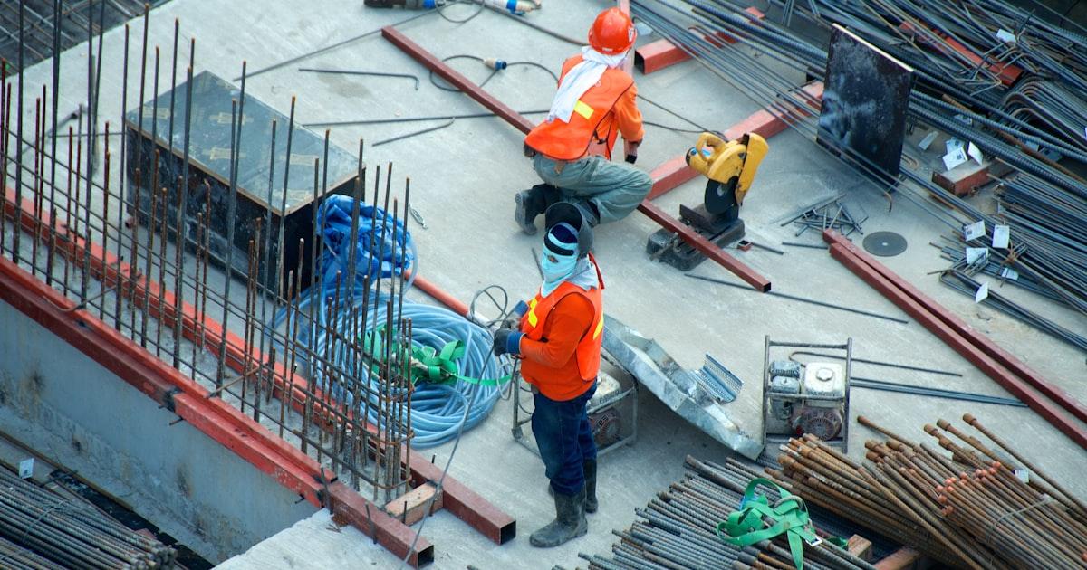 Mobile crane with boom extended on a construction site, representing 2026 used crane pricing data